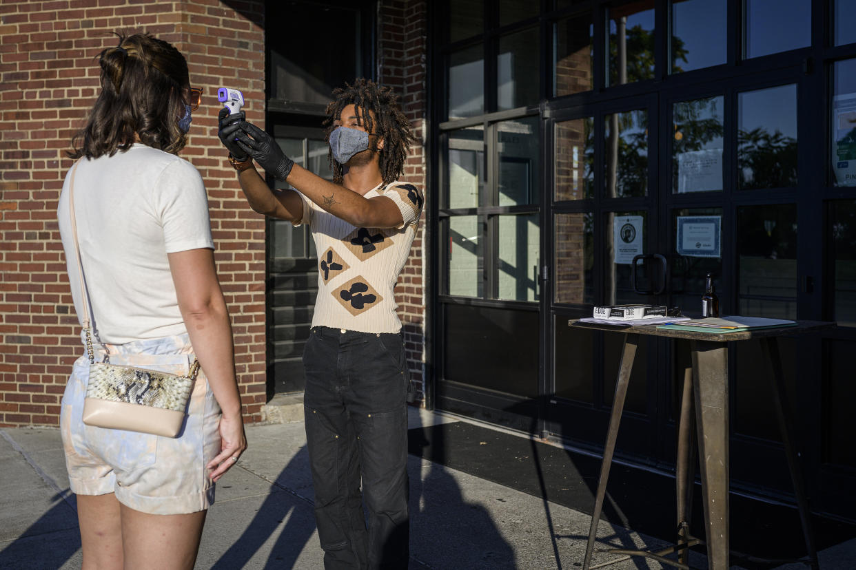 Un recepcionista del restaurante Pinewood Social revisa la temperatura de un comensal en Nashville, Tennessee, el 7 de agosto de 2020. (William DeShazer/The New York Times)