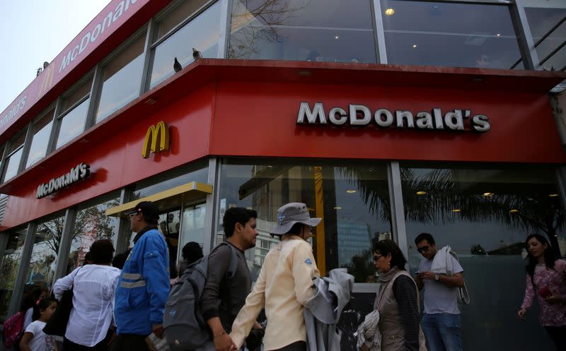 FILE PHOTO: People walk past McDonald's fast-food restaurant in Lima