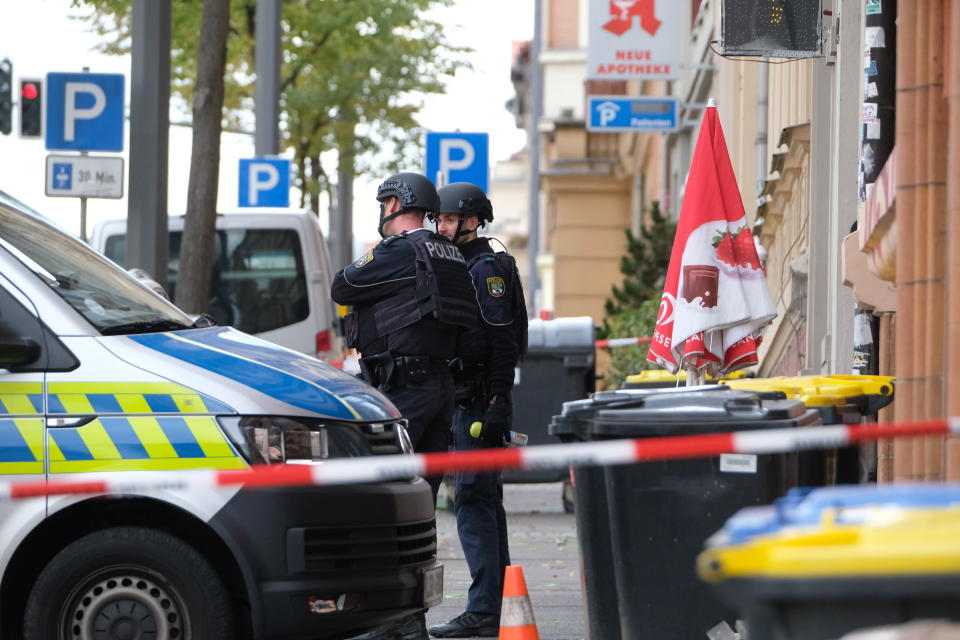 Police officers are seen at a crime scene in Halle, Germany, Wednesday, Oct. 9, 2019. A gunman fired several shots on Wednesday in the German city of Halle. Police say a person has been arrested after a shooting that left two people dead. (Sebastian Willnow/dpa via AP)