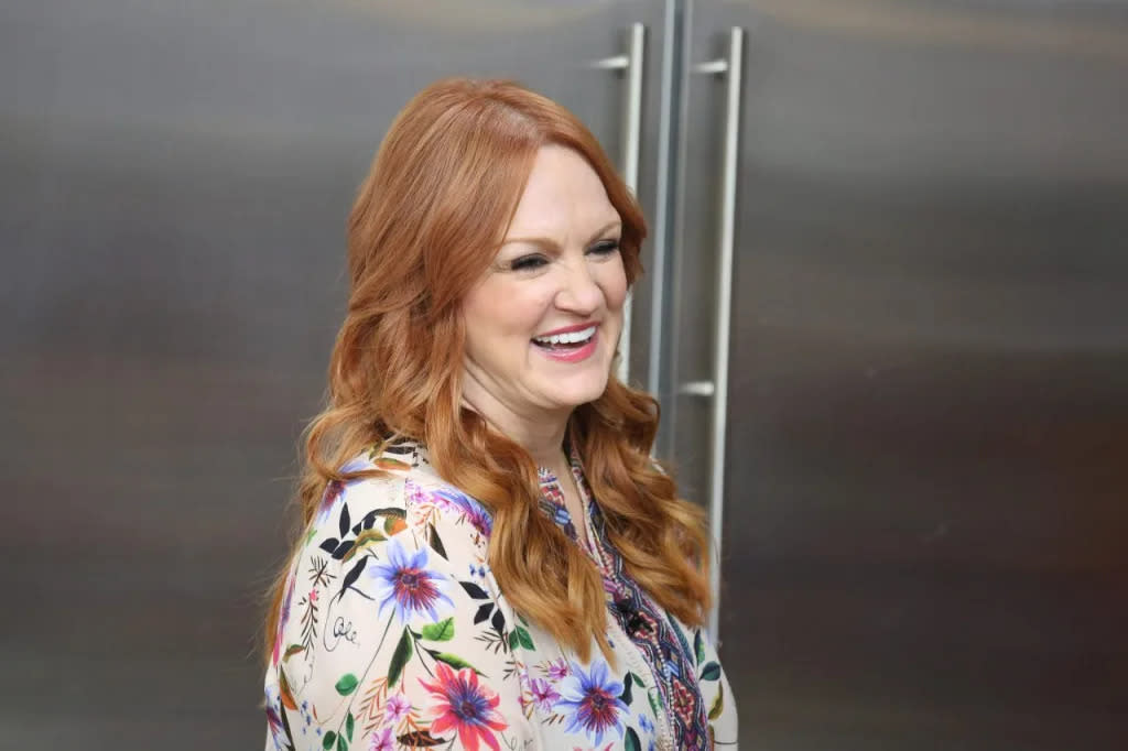 Pioneer Woman Ree Drummond, standing in kitchen, welcomes new dog into family.