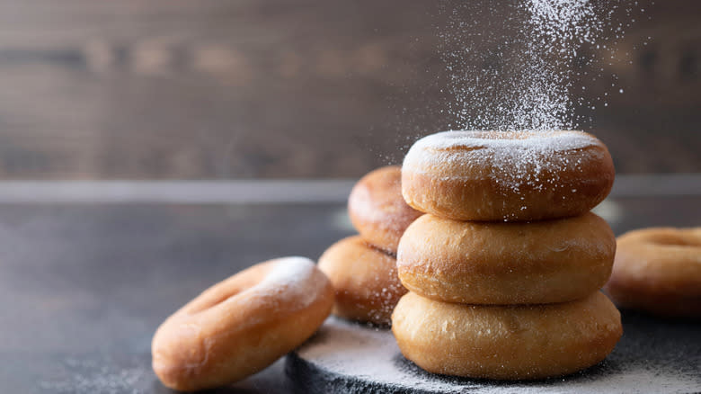 powdered sugar falling on fried donuts