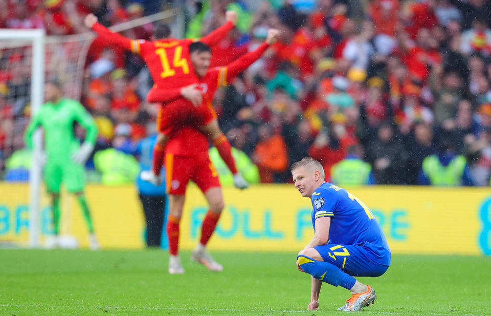 Oleksandr Zinchenko, pictured here looking dejected as Wales players celebrate.