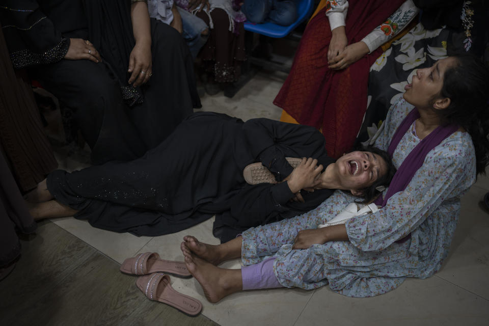 Daughter, cries holding the sandals of slain Mohammad Zillur, as family members wail at a hospital in Munshiganj, outside Dhaka, Bangladesh, Sunday, Jan. 7, 2024. Zillur, a supporter of a candidate from the ruling Awami League was stabbed to death on Sunday as Bangladesh voted in a parliamentary election boycotted by the main opposition party. (AP Photo/Altaf Qadri)