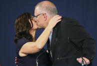 Australian Prime Minister Scott Morrison, right, kisses his wife, Jenny, after his opponent conceded defeat in the federal election in Sydney, Australia, Sunday, May 19, 2019. Australia's ruling conservative coalition, lead by Morrison, won a surprise victory in the country's general election, defying opinion polls that had tipped the center-left opposition party to oust it from power and promising an end to the revolving door of national leaders. (AP Photo/Rick Rycroft)