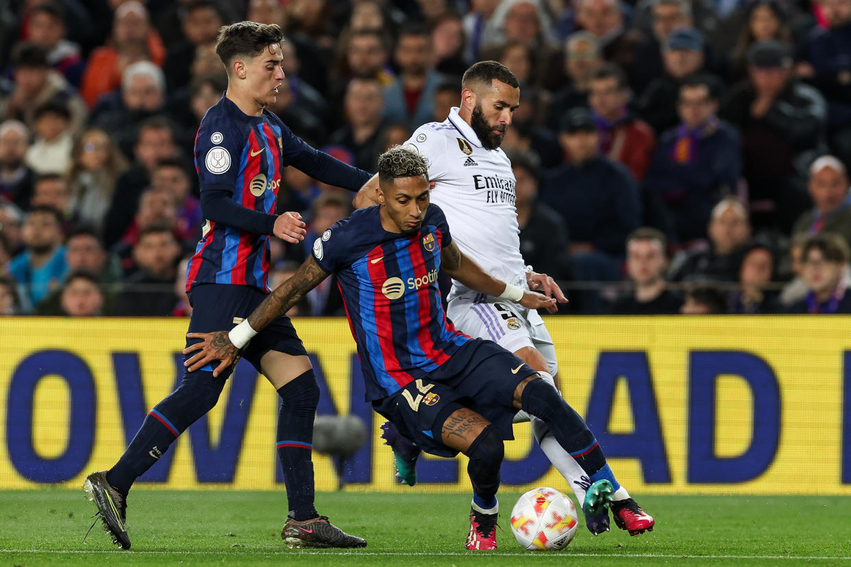 BARCELONA, SPAIN - APRIL 5: Barcelona's Brazilian forward Raphinha vies with Real Madrid's forward Benzema  during the Kings Cup semifinal second leg one match between FC Barcelona vs Real Madrid at at the Camp Nou stadium in Barcelona on April 5, 2023. (Photo by Adria Puig/Anadolu Agency via Getty Images)
