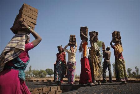 Labourers carry bricks to be baked in a kiln at a brickyard on the outskirts of Karad in Satara district, about 396km (246 miles) south of Mumbai February 13, 2012. REUTERS/Danish Siddiqui/Files