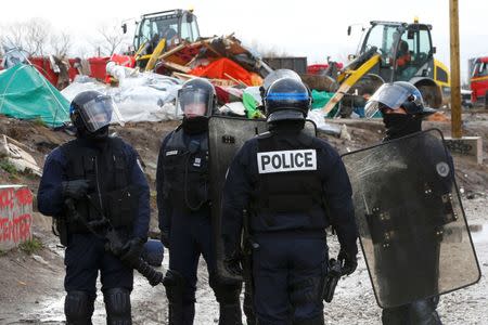 French police secure the area as workmen tear down makeshift shelters during the dismantlement of the migrant shanty town called the "Jungle" in Calais, France, March 3, 2016. REUTERS/Yves Herman