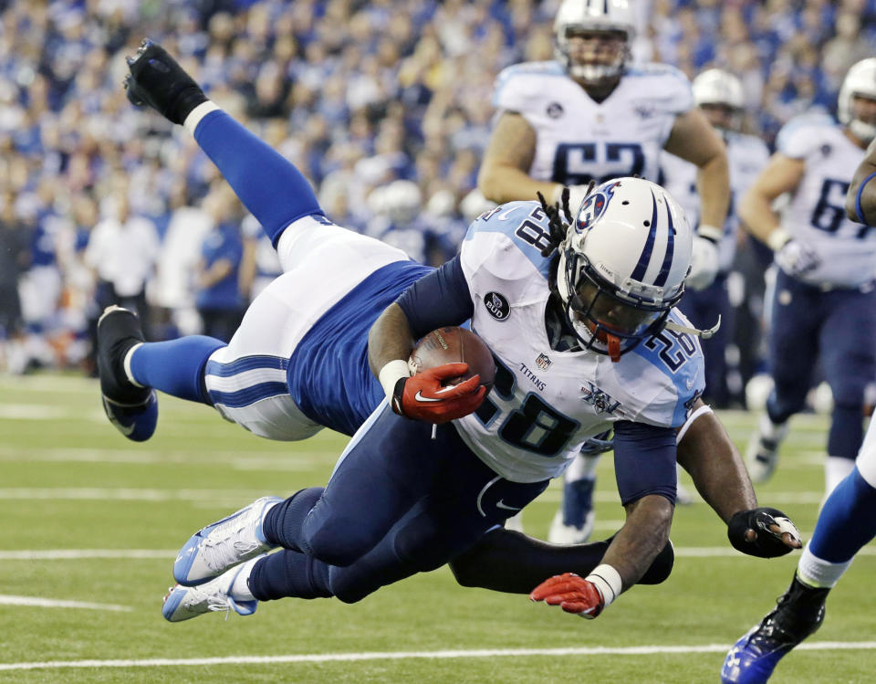FILE - In this Dec. 1, 2013 file photo, Tennessee Titans' Chris Johnson (28) dives while being tackled by Indianapolis Colts' Cory Redding during the first half of an NFL football game in Indianapolis. The Titans have told Chris Johnson they are releasing him after six seasons to avoid paying the $8 million the running back is due in pay in 2014, and the final three seasons left on the $53.5 million contract he signed in September 2011. The Titans announced Johnson has been told he will be released Friday, April 4, 2014. (AP Photo/Michael Conroy, File)