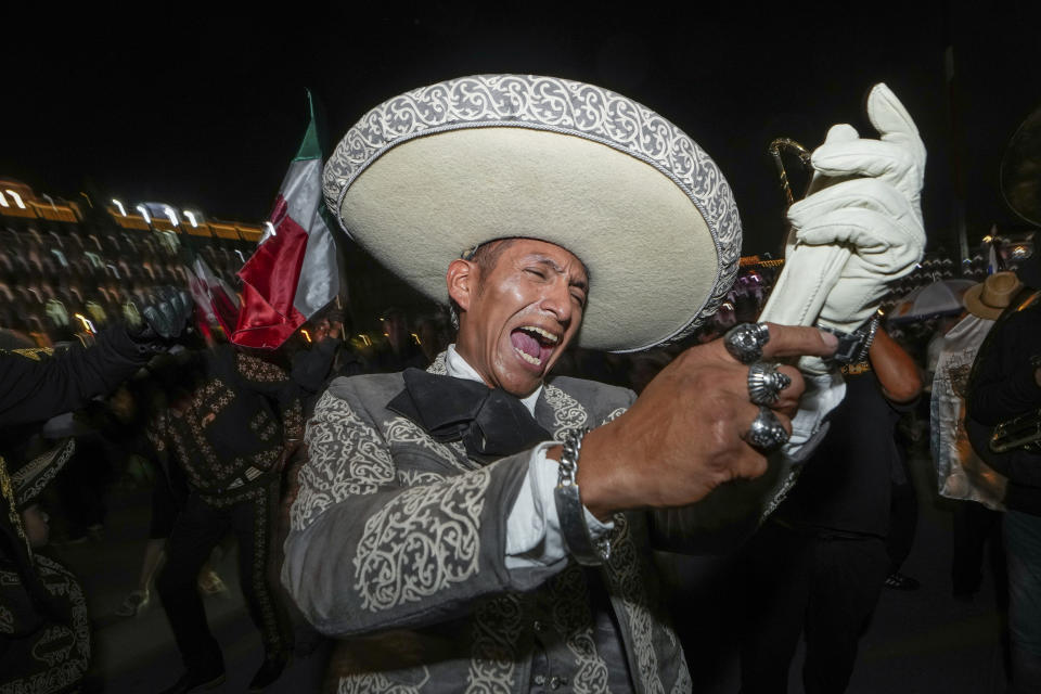 A man dressed in traditional clothing sings after the close of polls during general elections at the Zocalo, Mexico City's main square where supporters of ruling party presidential candidate Claudia Sheinbaum are gathering, Sunday, June 2, 2024. (AP Photo/Matias Delacroix)