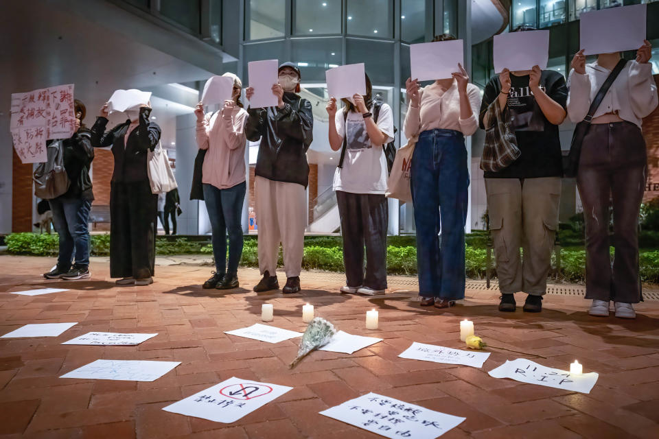 2022年，港大內地生在校園內舉白紙，站在點燃的蠟燭旁，聲援內地白紙運動。SOPA Images/LightRocket via Getty Images

