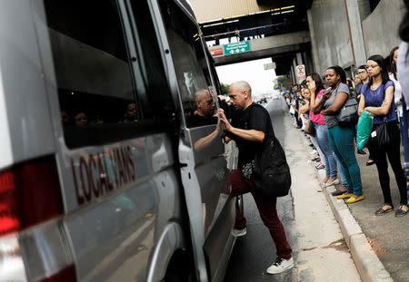 A commuter gets into a clandestine van at a local bus stop during a strike against Brazilian Social Welfare reform project from government, in Sao Paulo, Brazil March 15, 2017. REUTERS/Nacho Doce