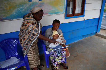 Claudine Kitsa who was discharged after being cleared of having Ebola, holds her daughter at a United Nations Children's Fund (UNICEF) creche for children whose families are suspected or confirmed Ebola cases, near the Ebola treatment centre in Butembo, Democratic Republic of Congo, March 28, 2019. REUTERS/Baz Ratner