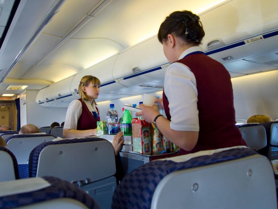Flight Attendants Serving Drinks on Plane