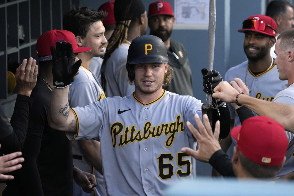 Pittsburgh Pirates' Jack Suwinski is congratulated by teammates in the dugout after hitting a solo home run during the fourth inning of a baseball game against the Los Angeles Dodgers Tuesday, July 4, 2023, in Los Angeles. (AP Photo/Mark J. Terrill)