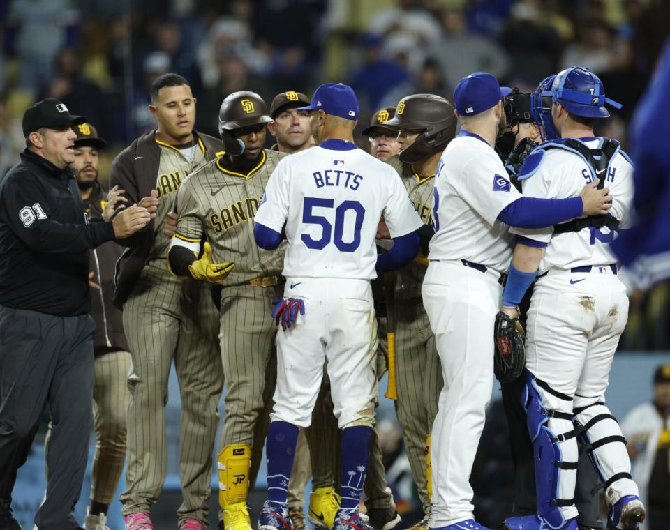 Los jugadores de los Dodgers y los Padres se enfrentan en el plato después de que las bancas se vaciaron durante la quinta entrada el sábado por la noche.