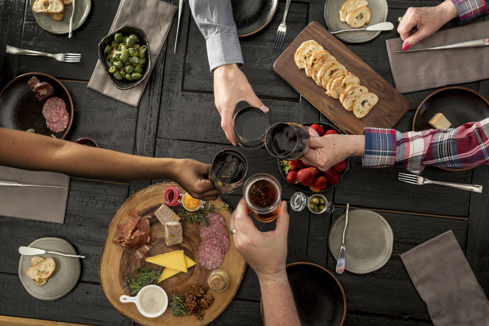 Friends sharing charcuterie and tapas with wine and beer