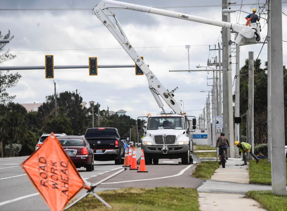 Workers from Pike Electric restore power Thursday in Indialantic after disruptions from Hurricane Nicole.