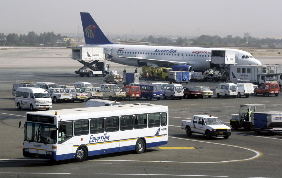 FILE - In this Monday April 21, 2008 file photo, a bus and a plane are seen at the Cairo International airport, in Egypt. Cairo airport officials say seven flights to Egypt have been cancelled and that others are arriving with less than 50 percent occupancy following weekend clashes that killed scores. (AP Photo/Amr Nabil, File)