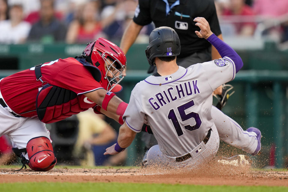 Washington Nationals catcher Keibert Ruiz, left, tags out Colorado Rockies' Randal Grichuk (15) at home during the fourth inning of a baseball game at Nationals Park, Monday, July 24, 2023, in Washington. (AP Photo/Alex Brandon)