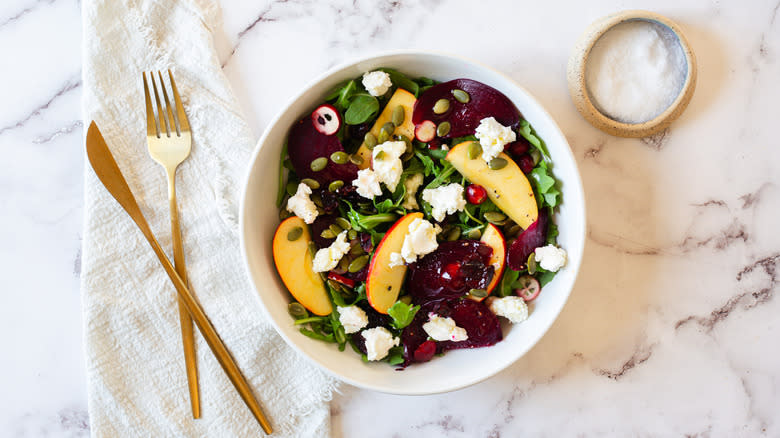 overhead view of salad with cutlery and salt