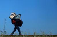 A migrant carries his pack on his back as he crosses the border between Serbia and Hungary near Roszke village on September 13, 2015