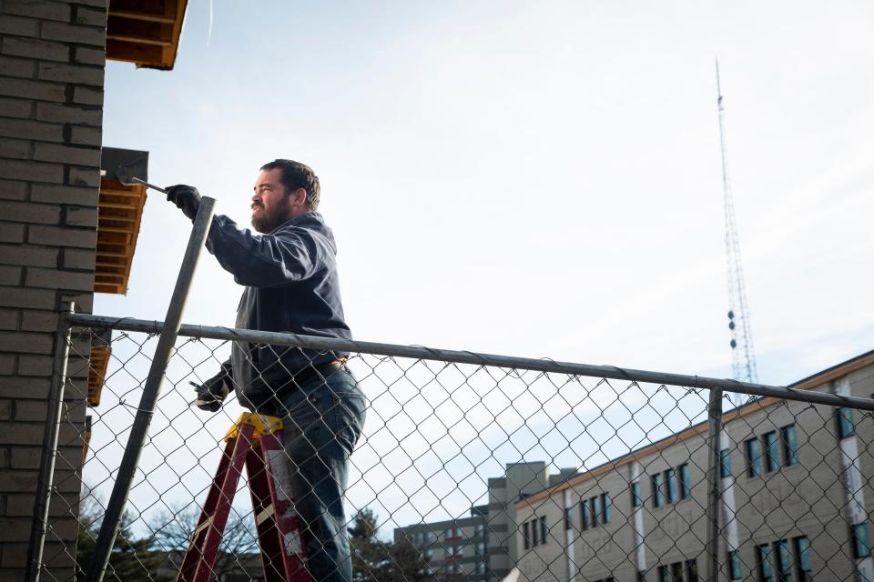 Jaron Rohde works on installing anchor bolts for awnings on the new Cityview townhome development along Keo Way and I-235 on Thursday, Dec. 19, 2019, in Des Moines.