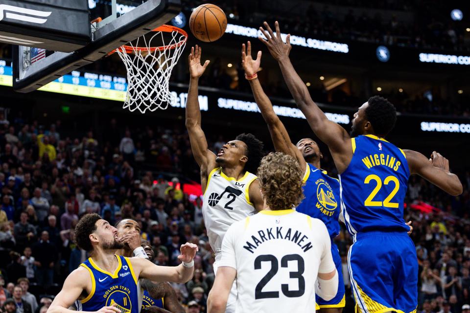 Utah Jazz guard Collin Sexton (2) shoots a layup with Golden State Warriors forward Jonathan Kuminga (00) and Golden State Warriors forward Andrew Wiggins (22) jumping up on defense in the NBA basketball game between the Utah Jazz and the Golden State Warriors at the Delta Center in Salt Lake City on Thursday, Feb. 15, 2024. | Megan Nielsen, Deseret News