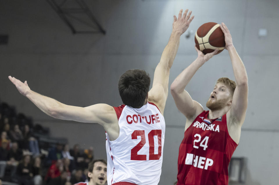 Switzerland's Arnaud Cotture, left, in action against Croatia's Dario Dreznjak during the FIBA Eurobasket 2025 Pre-Qualifiers game between Switzerland and Croatia at the St. Leonard hall in Freibourg, Switzerland, Thursday, Feb. 23, 2023. (Peter Schneider/Keystone via AP)