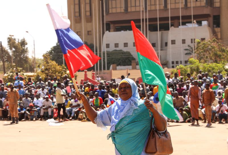 FILE PHOTO: A woman holds her national flag Russian's as people gather to show their support to the Junta leader Ibrahim Traore and demand the departure of the French ambassador in Ouagadougou