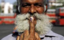 An Indian man displays the indelible ink mark on his finger after casting his vote in Mumbai India, Thursday, April 24, 2014. The multiphase voting across the country runs until May 12, with results for the 543-seat lower house of parliament expected on May 16. (AP Photo/Rajanish Kakade)