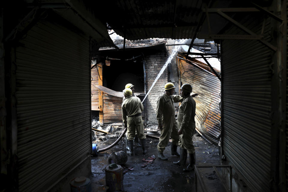 Fire fighters douse a fire at Gokul puri tyre market which was burnt Tuesday in New Delhi, India, Wednesday, Feb. 26, 2020. At least 20 people were killed in three days of clashes in New Delhi, with the death toll expected to rise as hospitals were overflowed with dozens of injured people, authorities said Wednesday. The clashes between Hindu mobs and Muslims protesting a contentious new citizenship law that fast-tracks naturalization for foreign-born religious minorities of all major faiths in South Asia except Islam escalated Tuesday. (AP Photo/Manish Swarup)