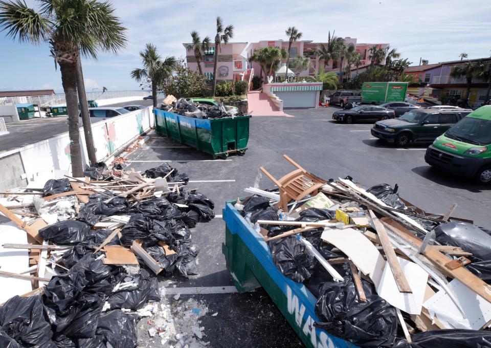 A Dumpster is filled up from debris at the Tropical Manor on the Ocean from damage wrought by Tropical Storm Ian in Daytona Beach Shores, Tuesday, Oct. 11, 2022.