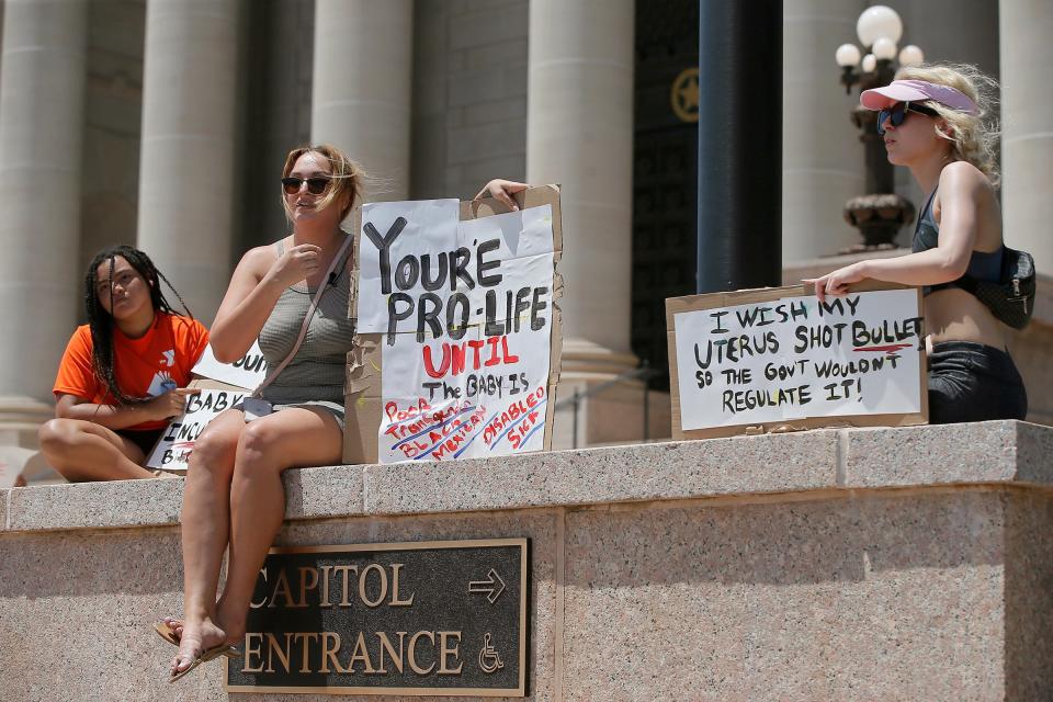 Demonstrators Kaitlyn Ramsey, Megan Ramsey and Alexis Scott, from left, gather outside of the Oklahoma state Capitol to protest against the Supreme Court's decision to overturn legal abortions on Friday, June 24, 2022, in Oklahoma City, Okla. 