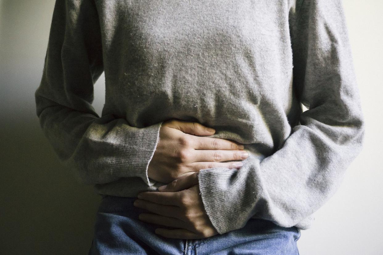 woman with pelvic pain, hugging stomach