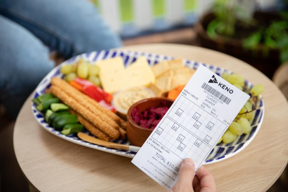 Winning Keno ticket in front of a platter of food. 