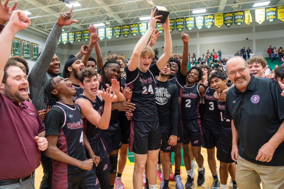 The Rutgers Prep boys basketball team celebrates after beating Montgomery to win the Somerset County Tournament championship on Feb. 17, 2024