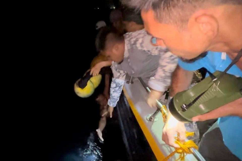 Philippine Coast Guard personnel plucks a survivor from the waters (AP)