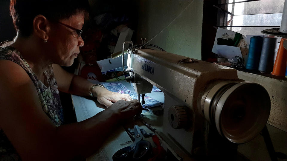 A seamstress sews protective masks to be donated to residents affected by the erupting Taal Volcano