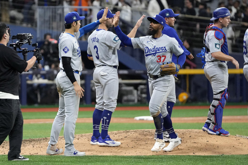 Los Angeles Dodgers designated hitter Shohei Ohtani, second from left, congratulates Teoscar Hernandez after the Dodgers defeated the San Diego Padres 5-2 in an opening day baseball game at the Gocheok Sky Dome in Seoul, South Korea Wednesday, March 20, 2024, in Seoul, South Korea. (AP Photo/Lee Jin-man)