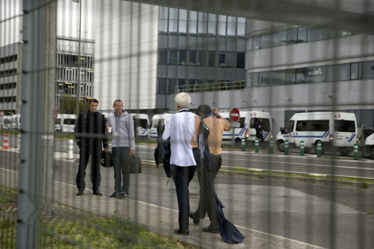 The director of human resources of Air France, Pierre Plissonnier (L), and Air France executive Xavier Broseta, walk away from demonstrators protesting in Roissy-en-France, on October 5, 2015