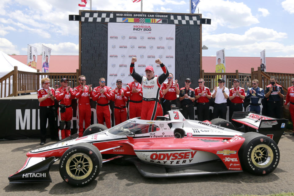 Scott McLaughlin, center, celebrates in Victory Circle after winning an IndyCar auto race at Mid-Ohio Sports Car Course in Lexington, Ohio, Sunday, July 3, 2022. (AP Photo/Tom E. Puskar)