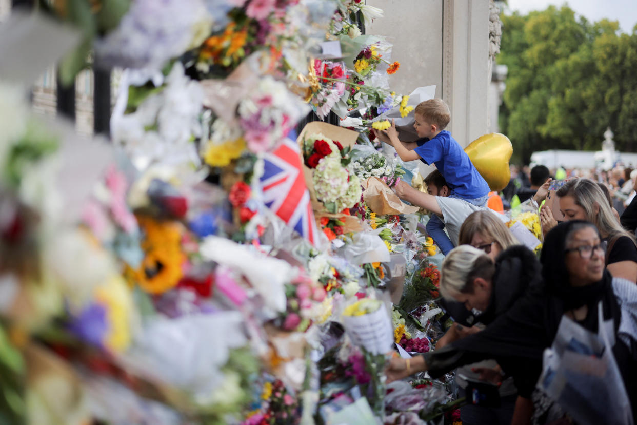 A boy places flowers, following the death of Britain's Queen Elizabeth, in London, Britain September 11, 2022. REUTERS/Marko Djurica