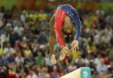 Simone Biles competes on the beam during the women's qualifications. REUTERS/Mike Blake