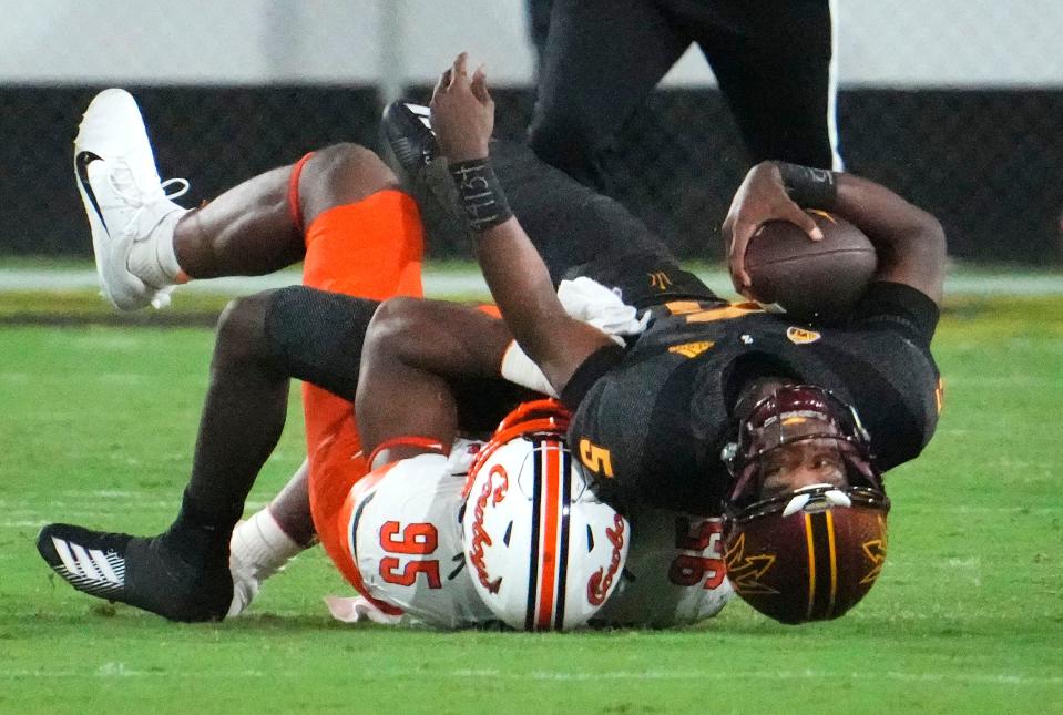 Arizona State Sun Devils quarterback Jaden Rashada (5) is tackled by Oklahoma State Cowboys defensive end Jaleel Johnson (95) in the second half at Mountain America Stadium in Tempe on Sept. 9, 2023.