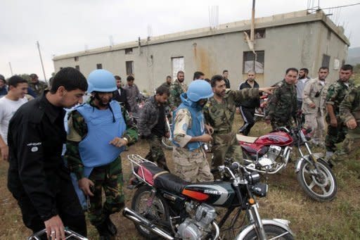 A man wearing a black shirt bearing an Al-Qaeda logo speaks with a UN observer in the Syrian village of Azzara on May 4. There are now about 60 UN ceasefire observers in Syria and the full force of 300 sent by the UN Security Council is expected to be in place before the end of May