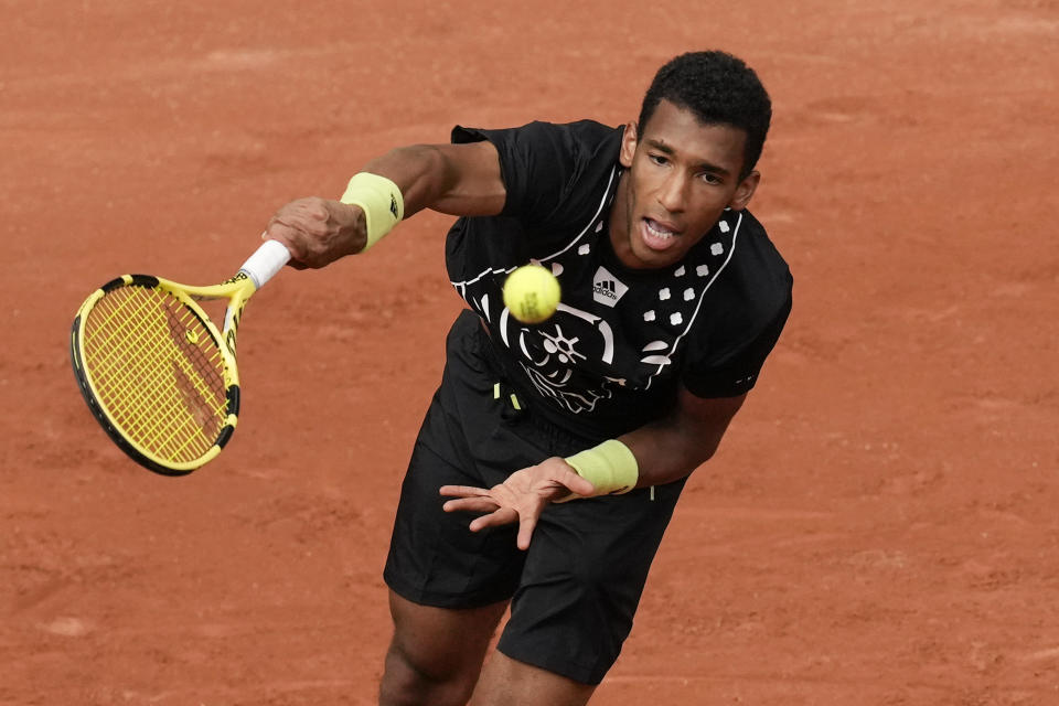 Canada's Felix Auger-Aliassime serves against Peru's Juan Pablo Varillas during their first round match at the French Open tennis tournament in Roland Garros stadium in Paris, France, Sunday, May 22, 2022. (AP Photo/Christophe Ena)