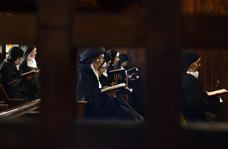 In this Thursday, Dec. 22, 2011 photo, Mother Dolores Hart, far right through middle window, and others in the Abbey of Regina Laudis participate in two of their seven daily prayers in their monastery in Bethlehem, Conn. Mother Dolores, a cloistered nun whose luminous blue eyes entranced Elvis Presley in his first on-screen movie kiss, is praying for a Christmas miracle. She walked away from Hollywood stardom in 1963 to become a nun in rural Bethlehem. Now she finds herself back in the spotlight, but this time it's all about serving the King of Kings, not smooching the King of Rock and Roll. The former brass factory that houses Mother Dolores and about 40 other nuns cloistered at the Abbey of Regina Laudis needs millions of dollars in renovations to meet fire and safety codes, add an elevator and make handicap accessibility upgrades. (AP Photo/Jessica Hill)
