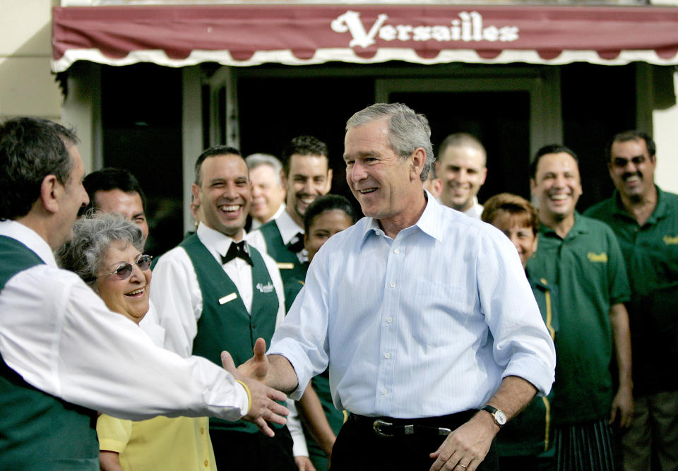 President George W. Bush greets cafe staff and workers after breakfast with business leaders at Versailles in Miami on July 31, 2006. (John Van Beekum / Miami Herald via Getty Images file)