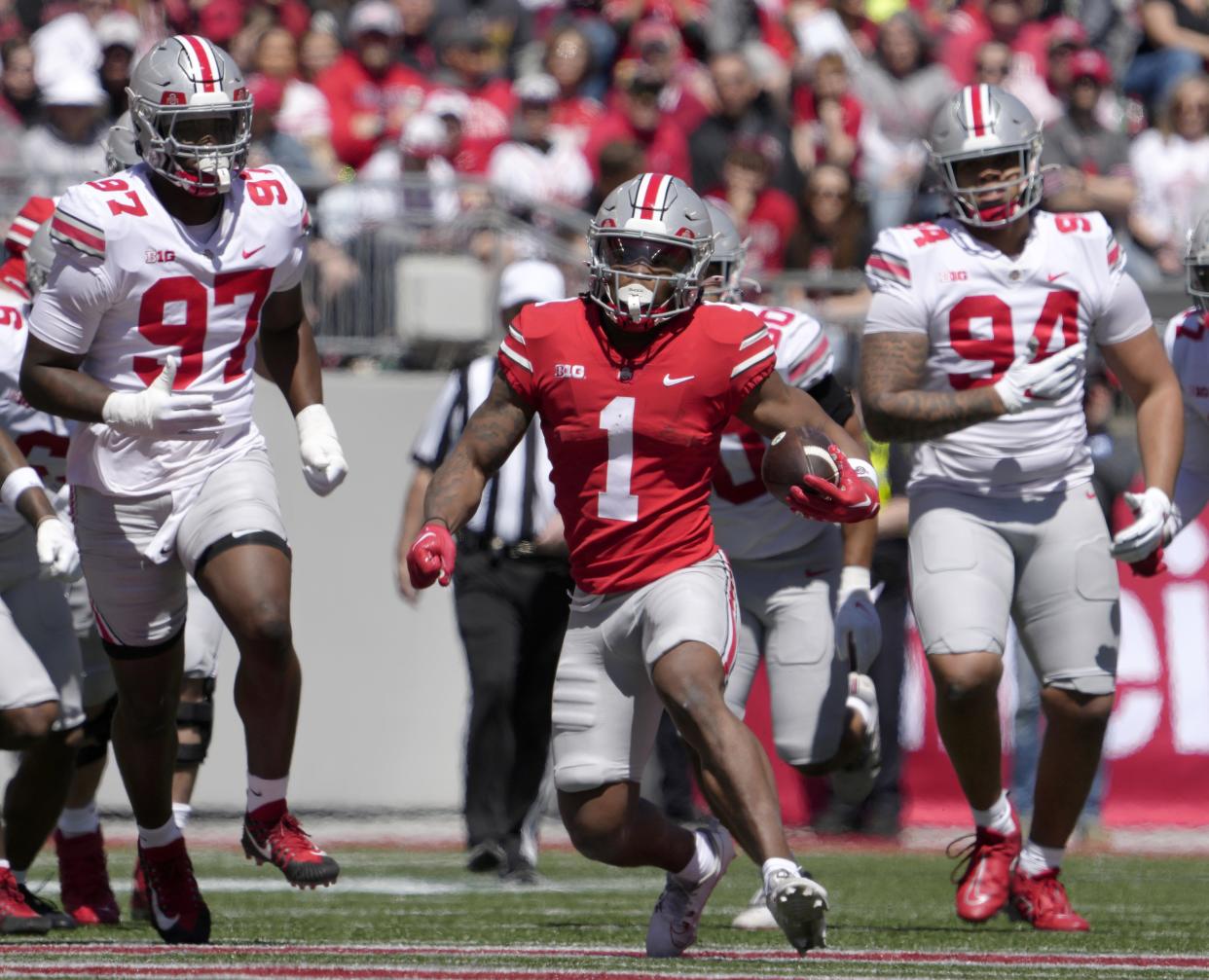 April 13, 2024; Columbus, Ohio, USA; 
Ohio State Buckeyes running back Quinshon Judkins (1) runs the football for the scarlet team while pursued by defensive end Kenyatta Jackson Jr. (97) and Jason Moore (94) of the grey team during the first half of the LifeSports spring football game at Ohio Stadium on Saturday.
