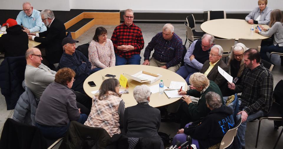 Republican Caucus goers talk to each other in their precinct meeting during the party caucus at Oakwood Road City Church Monday night.